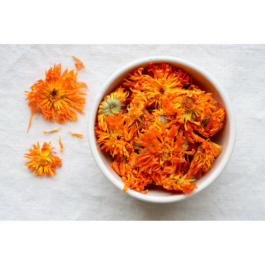 Picture of Organic Calendula bright orange on cloth and in bowl for display